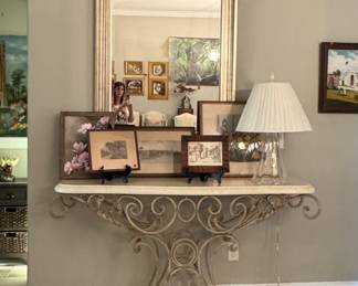 Entry table with modern mirror and lots of art