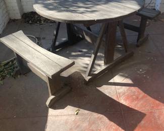 A nice outdoor round table and two benches