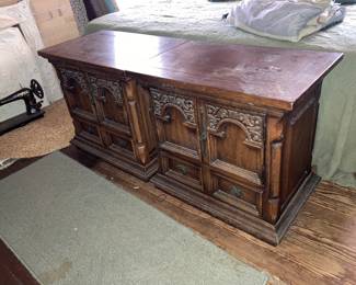 In a bedroom upstairs, there’s a Chest of  drawers with two matching bedside tables and a bed.
