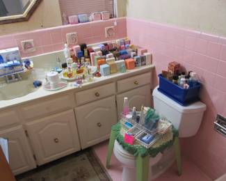 1956 Mid-century bathroom full of perfumes and toiletries.