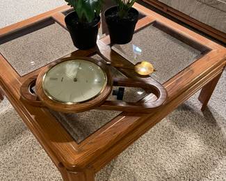Coffee table with smoked glass and maple wood,  Seiko wall clock and faux plants