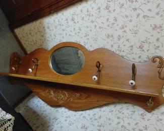 Antique wooden wall rack with oval mirror and porcelain knob hooks 