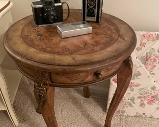 Hand-painted side table and vintage cameras