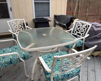 Glass patio table w/4 chairs, cushions and cover. Also a propane fire pit