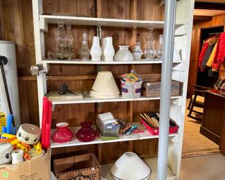 more oil lamps, chimneys and glass shades, old wooden crates. 
