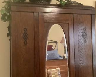 Antique armoire with oval mirror.  Has clothes hanger inside.  Excellent condition.
