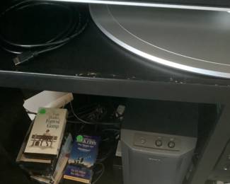 Tapes, speakers and DVD player under entertainment center.