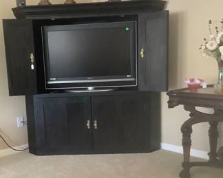 The beautiful hand made entertainment center holding a flat screen TV.