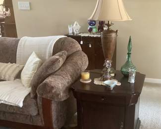 A close up of the end of couch and close-up of 1 of the end tables.
