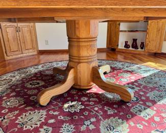 Large 72” diameter oak wood dining table.  The top to this table is one solid piece and comes with full table pads, four side chairs and two captains chairs