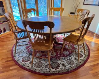 Large 72” diameter oak wood pedestal dining table.  The top to this table is one solid piece and comes with full table pads, four side chairs and two captains chairs