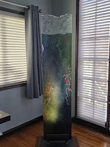 Solid Glass Sculpture by Local Artist. This has a backlight which shows the beautiful veins of varying colors throughout it. 