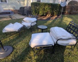 B8 - $300.  Brown Jordan Patio Set.  2 Chairs w/ottomans and side table. Table w/umbrella and four chairs. Some visible peeling.  Pillows wrapped to protect from weather. 