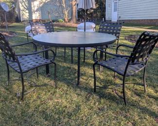 B8 - $300.  Brown Jordan Patio Set.  2 Chairs w/ottomans and side table. Table w/umbrella and four chairs. Some visible peeling.  Pillows wrapped to protect from weather. 