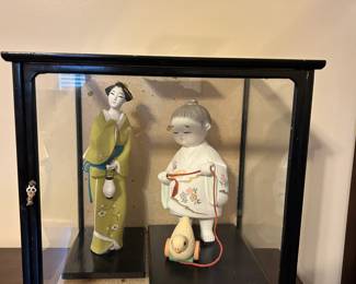 #24 glass case with 2 Asian statues, one is little girl with chicken, other is lady with lantern, 15" square $40.00