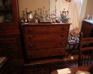 Silver and silver plate on most surfaces in the dining room.