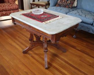 Table that was cut down to make coffee table height, marble top. Now stands in a small hall under the staircase on the first floor.