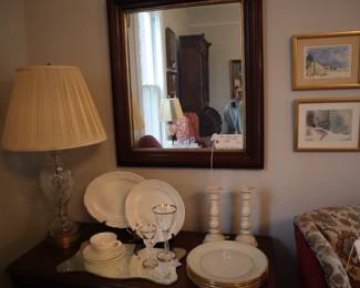 That chest now with a display of antique white china and a pair of painted white candle holders, and a set of 6 Lenox plates. In the living room.