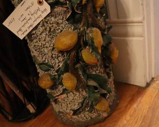Large hand thrown umbrella stand with hand applied details of lemons, leaves and wood detail. Full of wooden handmade canes. In the dining room. 