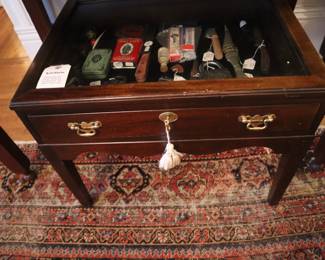 A display table with masculine items, under the Butler's desk, in the front entrance room.