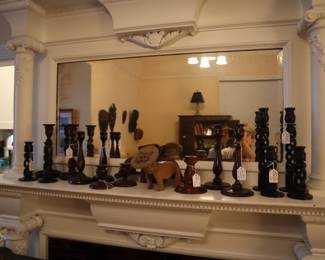 Wooden candleholders with a handmade lion ceramic item on the mantel in the downstairs, staircase room.