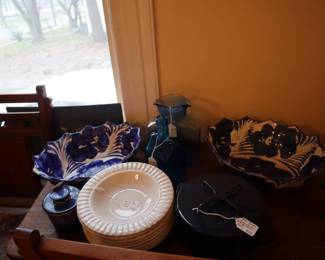 The blue and white matching large serving bowls, Dansk blue small dutch oven, white bowls on top of the 1 drawer table in the staircase room. 