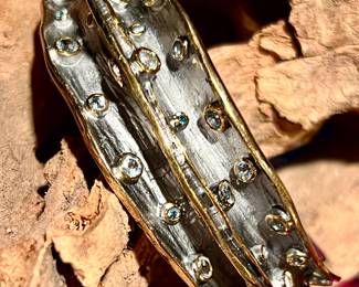 STERLING CUFF LINED WITH GOLD AND STUDDED WITH BLUE TOPAZ.  REMOVED DAILY.