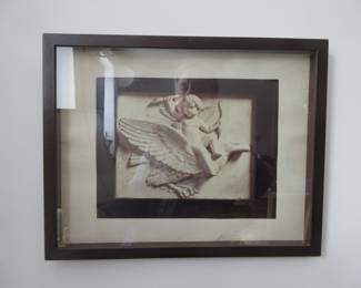 Recessed, framed photo of angel in relief.