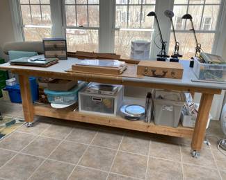 Very large project table. Originally used by a seamstress. Art and craft items. 3 MC lamps, paper ephemera in tubs,  the latter sold by lot..