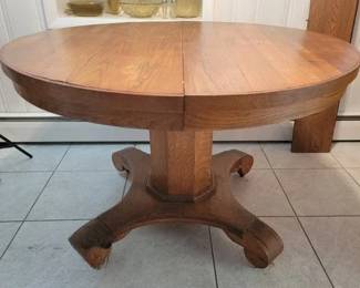Round pedestal oak table with two leaves