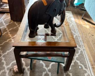 Great mid century modern coffee table with wooden carved elephant sitting on it 