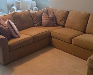 Tan sectional and white arm chair