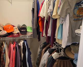 Closet of mostly men's clothes.