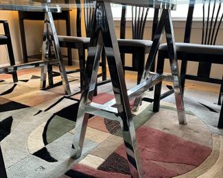 A3 - $200. Chrome Sawhorse Base with LARGE Glass top. Glass measures 5' x 7'. You will need a couple STRONG people to move the glass out! Includes 6 regular chairs. 2 arm chairs.