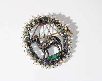 Antique Victorian Ladies Brooch of a Camel in the oasis, brooch has rubies sapphires, emerald and small natural seed pearls as well as diamond macles, one diamond macle is missing off the camel, brooch is approx 2" long and 1.5" wide, clasp is a "C"
