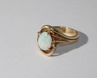 18kt yellow gold Opal & Diamond Ring that features a prong set oval opal approx. 2.5ct with strong red and green pinfire and accented with round diamond on each side in heavy 18kt gold mounting weighing 10.03 grams total weight, size 7.75, Fantastic Ring