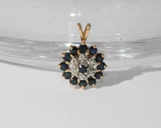 10kt yellow gold Sapphire & Diamond Pendant with center set round sapphire surrounded by halo of round diamond and further accented by round sapphires on out edge, 2.2 grams total weight