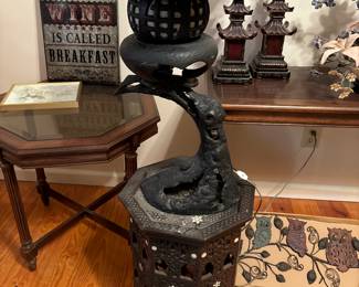 This is a cast iron lamp on top of a carved wooden table