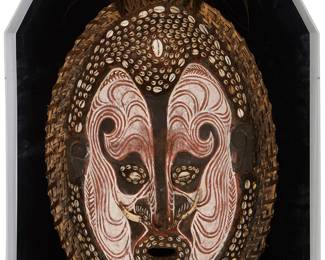 1104
20th century; Sepik River region, Papua New Guinea
A Papuan polychrome wood spirit mask
The painted carved wood mask with border woven from fibrous plant material, mounted with cowrie shells, bone nostril adornments, and cassowary feathers, housed in a custom Plexiglas case
Mask overall: 31" H x 15.5" W x 4" D, approximately; Case: 35.25" H x 20" W x 5.75" D
Estimate: $300 - $400