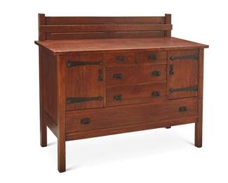 1072
Early 20th century; Fayetteville, NY
An L. & J.G. Stickley sideboard, No. 735
Unmarked
The fumed quarter-sawn oak sideboard with hammered copper hinges, pulls, and hardware, featuring four middle drawers centering opposed locking cabinets above a long lower drawer, surmounted by a plate storage rack
46" H x 56.25" W x 22.75" D
Estimate: $1,000 - $2,000