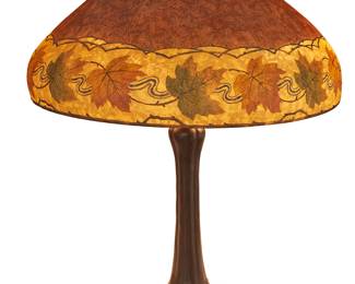 1171
Early 20th century; Meriden, Connecticut
A Handel maple leaf table lamp
Shade impressed: Handel Lamps Pat'd No. 979664; shade signed: HANDEL 6428 1/2; base stamped: HANDEL
Designed circa 1917, the domed "Teroma" glass shade with a lower border of vines and maple leaves, raised on a three-light patinated metal biomorphic base, electrified
Overall: 24" H x 18" W; Shade height: 8" H
Estimate: $1,500 - $2,500