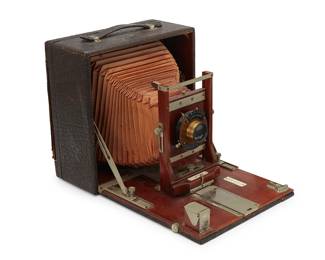 1236
1907
A Conley Safety folding bed revolving back camera
Marked: Conley; further marked to brass lens case: Conley Safety
The 120mm film camera with hinged door revealing the wood and brass apparatus, with leather bellows, housed in a leather-wrapped wood handled case
Stored: 9.25" H x 9" W x 4" D; Open: 13" D
Estimate: $400 - $600