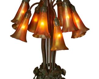 1169
Late 20th century
A Buffalo Studios twelve-light lily table lamp
Impressed to underside: Buffalo Studios / Pasadena CA; further impressed: 247, shaded unsigned
The patinated bronze Tiffany-style lamp with lily pad base issuing twelve curved stems, each ending in floriform iridescent glass shades, electrified
20.5" H x 16" W x 15" D
Estimate: $1,500 - $2,500