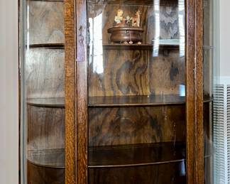 Antique oak bow front curio cabinet with wood casters
