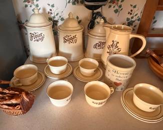 Flour, sugar and coffee containers. Pitcher and teacups with saucers