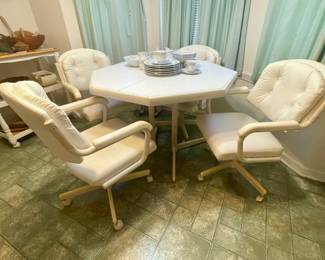 White, cream hexagonal shaped table with 4 padded rolling, swivel chairs