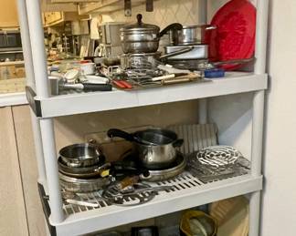 Shelf full of pots and pans, cooking utensils, racks...
