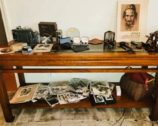 Entry table full of antique cameras, old photographs and Judaica