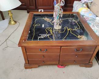 Square coffee table / with glass top . It is also a display table