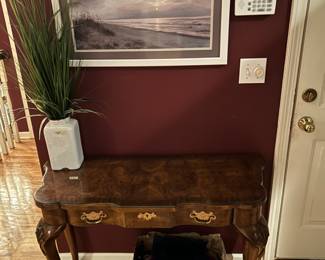 Beautifully crafted wooden table, with a unique wood grain and etching on the sides. Great condition! Painting, $1 box, and faux plant. 